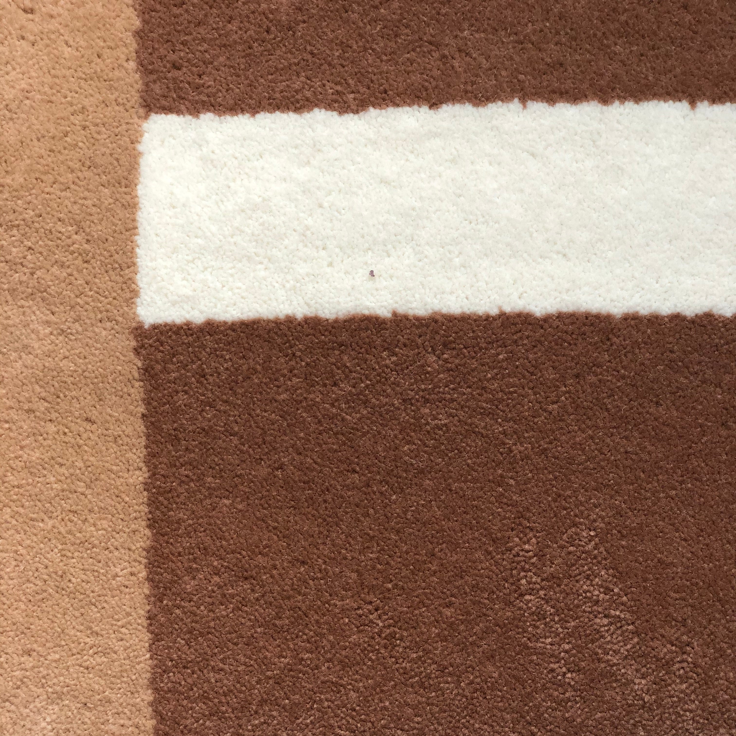 zoom sur le tapis seventies Baba couleur beige et crème! Ces formes géométriques sont inspirées de l’école du Bauhaus, donnant au tapis un style seventies et contemporain. Made in France & Fait Main Le tapis nait d’une collaboration avec PINTON, l’une des plus grandes références du tapis et de la tapisserie d’exception depuis maintenant 150 ans.