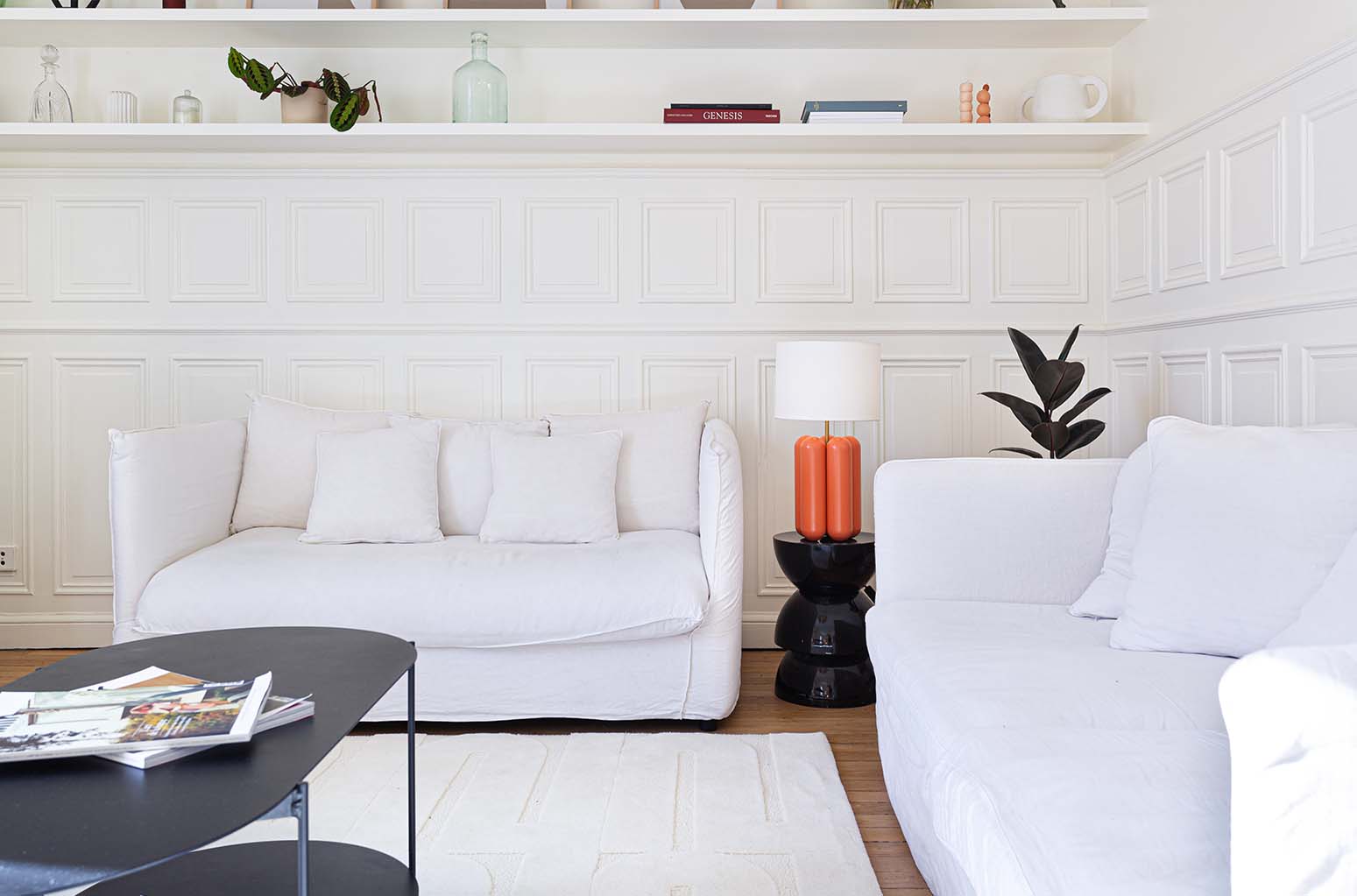 Le tapis blanc crème est mis en situation dans un salon avec la lampe charlotte corail. Le tapis made in france fait main. Le tapis est en laine couleur crème. Il y a un mélange de laine bouclée et laine velours ce qui lui donne un côté texturé, géométrique et contemporain.