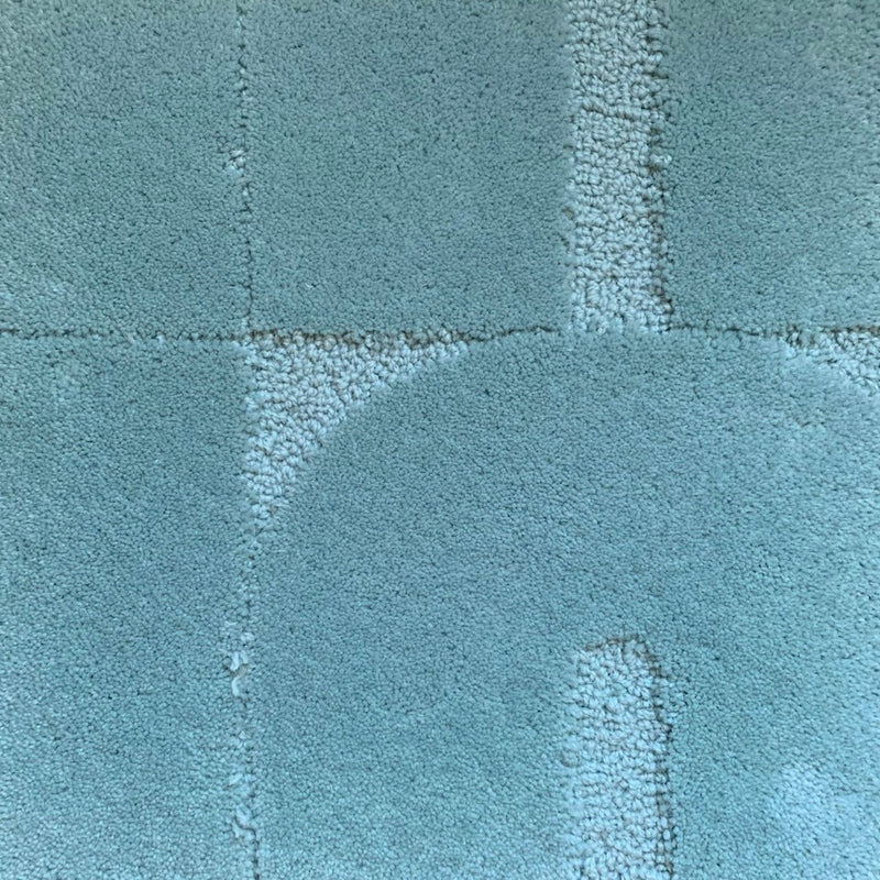 Zoom sur le tapis made in france bleu opaline. Le tapis seventies est un tapis made in france fait main. Le tapis est en laine bleu opaline. Il y a un mélange de laine bouclée et laine velours ce qui lui donne un côté texturé, géométrique et contemporain.