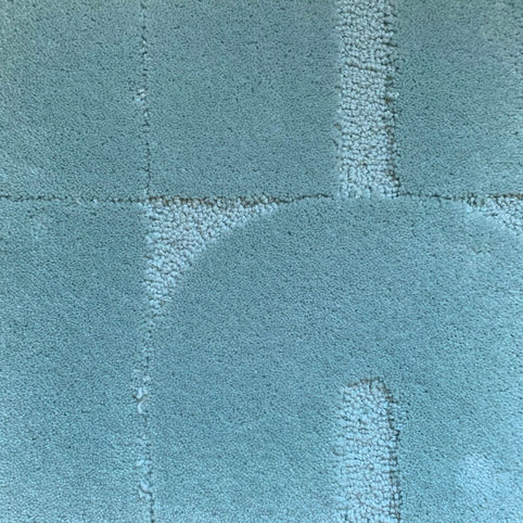 Zoom sur le tapis made in france bleu opaline. Le tapis seventies est un tapis made in france fait main. Le tapis est en laine bleu opaline. Il y a un mélange de laine bouclée et laine velours ce qui lui donne un côté texturé, géométrique et contemporain.