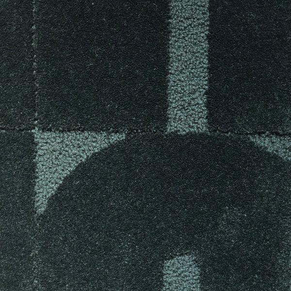 Zoom sur le tapis Made in France Opéra. Le tapis seventies est un tapis made in france fait main. Le tapis est en laine vert sapin. Il y a un mélange de laine bouclée et laine velours ce qui lui donne un côté texturé, géométrique et contemporain.