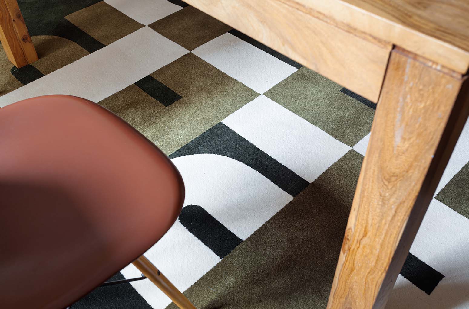 Zoom du tapis Seventies vert dans une salle à manger. Ces formes géométriques sont inspirées de l’école du Bauhaus, donnant au tapis un style seventies et contemporain. Made in France & Fait Main Le tapis seventies Baba nait d’une collaboration avec PINTON, l’une des plus grandes références du tapis et de la tapisserie d’exception depuis maintenant 150 ans. 